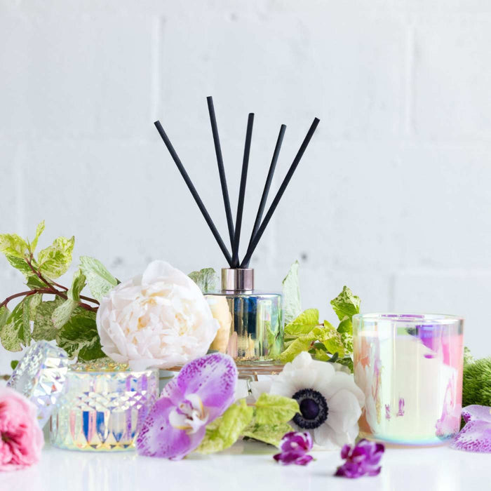 Launch of Stacy K Florals home fragrance line bloom in iridescent vessels with flowers around it