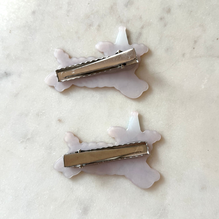 The silver backing of the hair clips with white marbled background