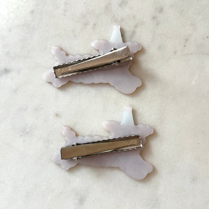 The silver backing of the hair clips with white marbled background