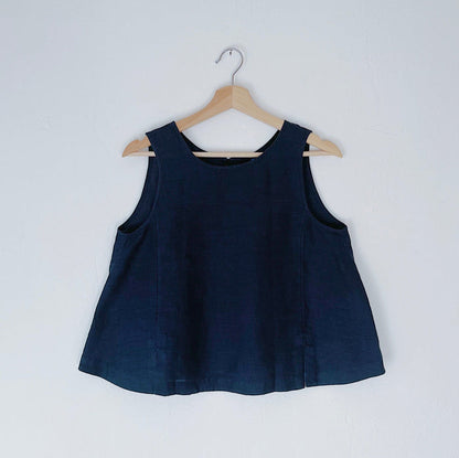 A navy linen tank top with buttons down the back and side slits, displayed on a hanger against a white background.