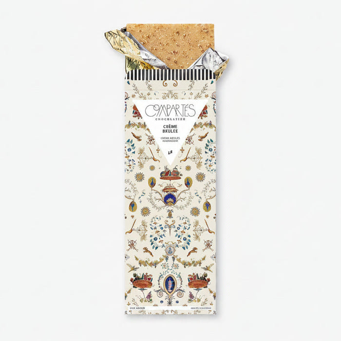 A chocolate bar with a decorative and colorful packaging, labeled 'Compartes Creme Brulee'.