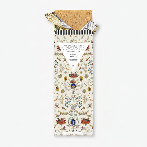 A chocolate bar with a decorative and colorful packaging, labeled 'Compartes Creme Brulee'.