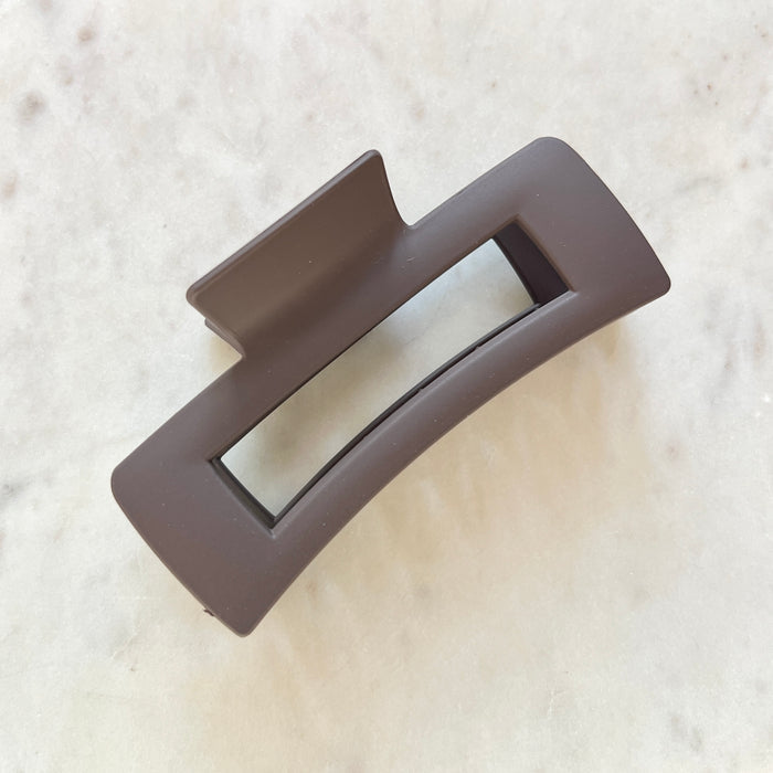 Gray rectangular hair claw on a textured beige background