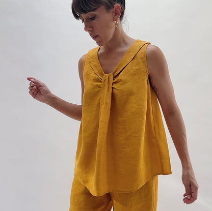 Three-quarter front view of the Sailor Tank in Turmeric by Yuvita, highlighting the gathered twist neckline and sailor collar detail in golden turmeric yellow linen, styled with matching wide-leg pants
