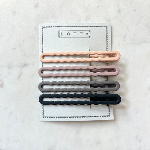 Set of four wavy hair clips in pink, gray, and black on a white card with 'Lotta' branding.