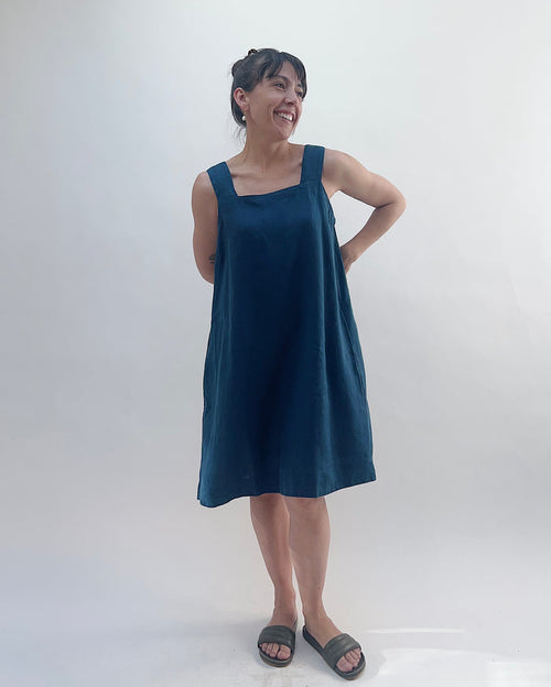 Woman wearing a blue dress standing against a white background