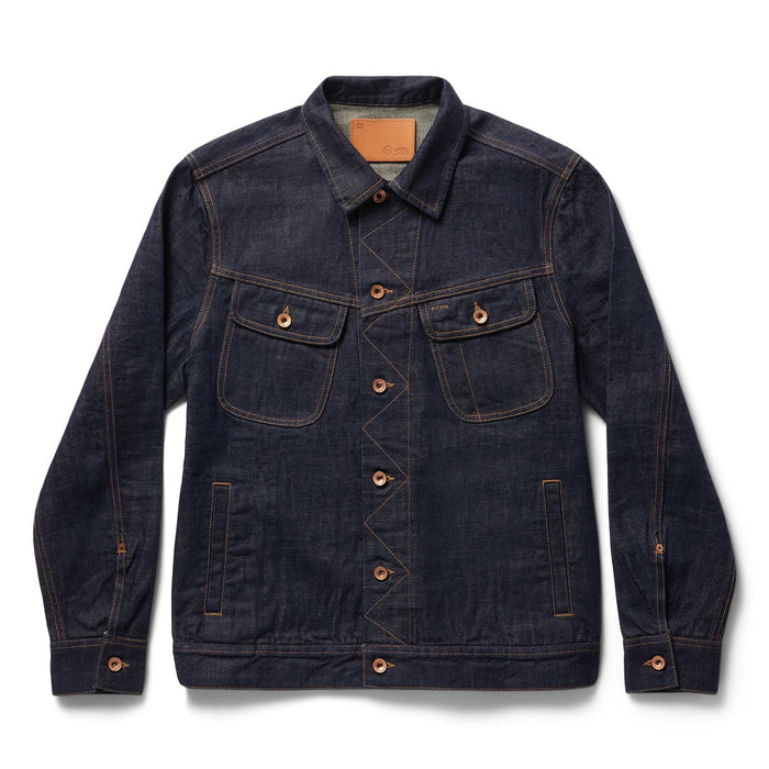 Front view of The Long Haul Jacket in Rinsed Organic Selvedge by Taylor Stitch, showing the dark indigo denim, dual chest pockets, copper buttons, and leather patch at the collar, on a white background