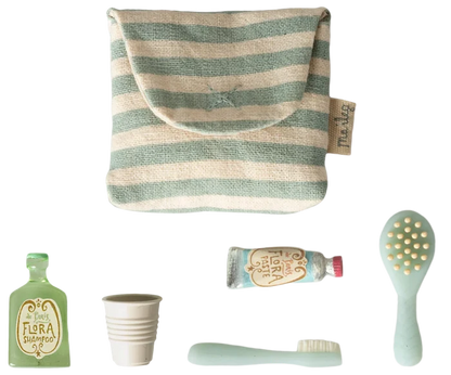 Maileg Toothbrush Set in Blue Striped Bag — flat lay of the blue and cream striped cotton toiletry bag with five miniature accessories: Flora Shampoo bottle, ribbed water cup, toothbrush, Flora Paste toothpaste tube, and hairbrush