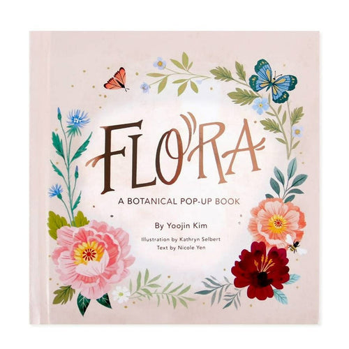 A light pink book with a floral and butterfly pattern. Rose gold foiled text reads "Flora a botanical pop-up book by Yoojin Kim, illustration by kathryn selbert, text by Nicole Yen.